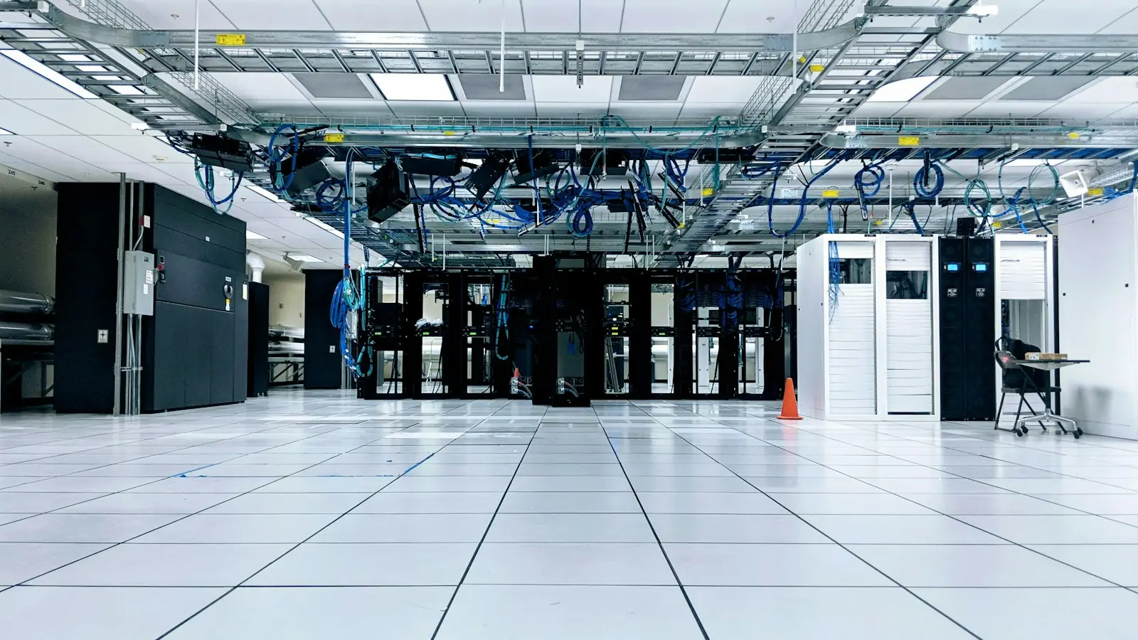 A data center hall with a white floor and server racks