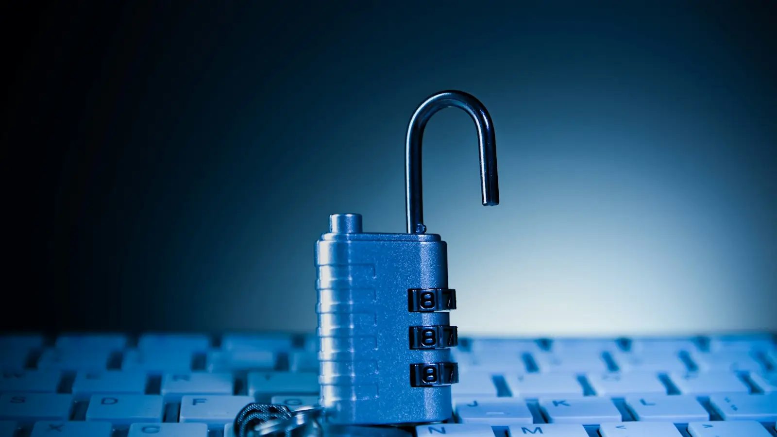 An open padlock on a keyboard in blue light